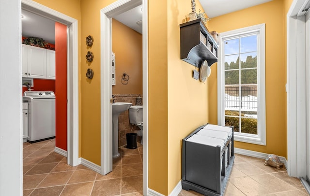 interior space with washer / dryer, plenty of natural light, baseboards, and tile patterned flooring