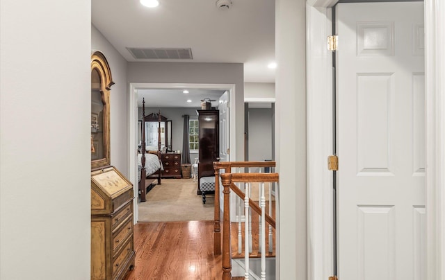 corridor featuring recessed lighting, visible vents, wood finished floors, and an upstairs landing