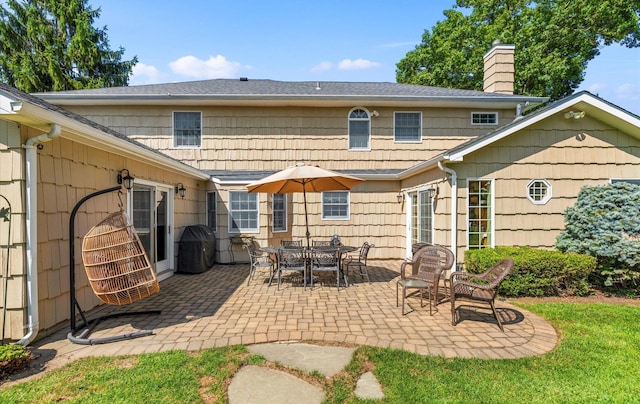 back of property featuring a patio and a chimney