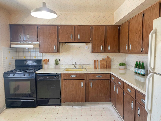 kitchen featuring light floors, under cabinet range hood, a sink, light countertops, and black appliances