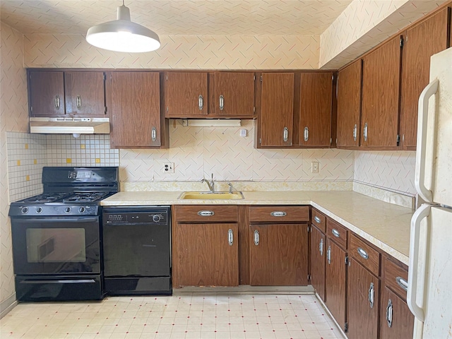 kitchen with light floors, under cabinet range hood, a sink, light countertops, and black appliances