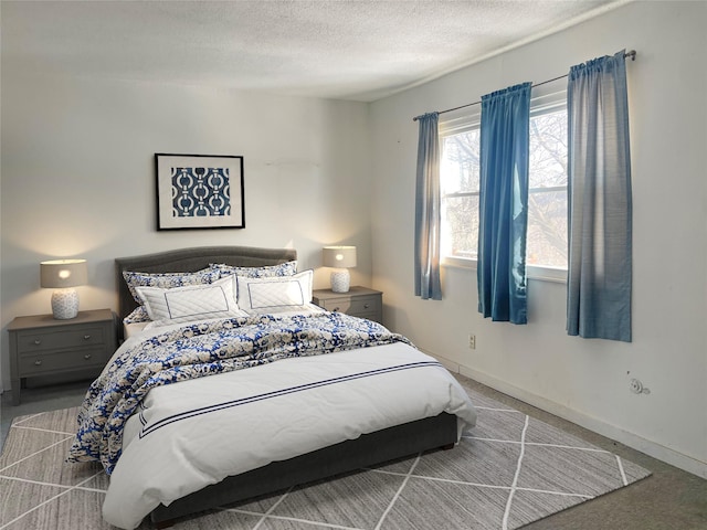 bedroom featuring carpet flooring, a textured ceiling, and baseboards