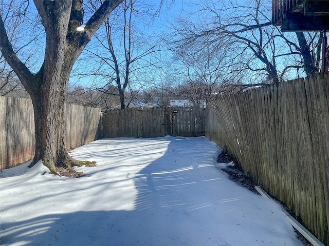 yard covered in snow with a fenced backyard