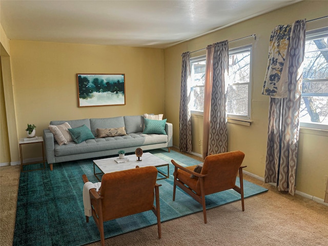 living area featuring light carpet and baseboards