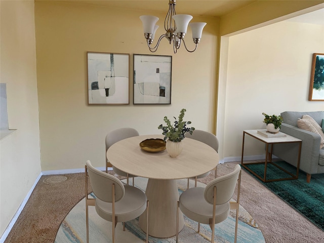 dining room with a notable chandelier, baseboards, and carpet flooring