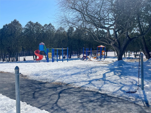 snow covered playground with playground community and fence