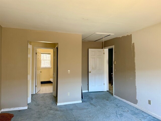 interior space with baseboards, attic access, and carpet flooring