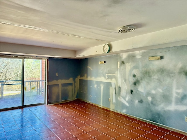 tiled empty room featuring baseboards