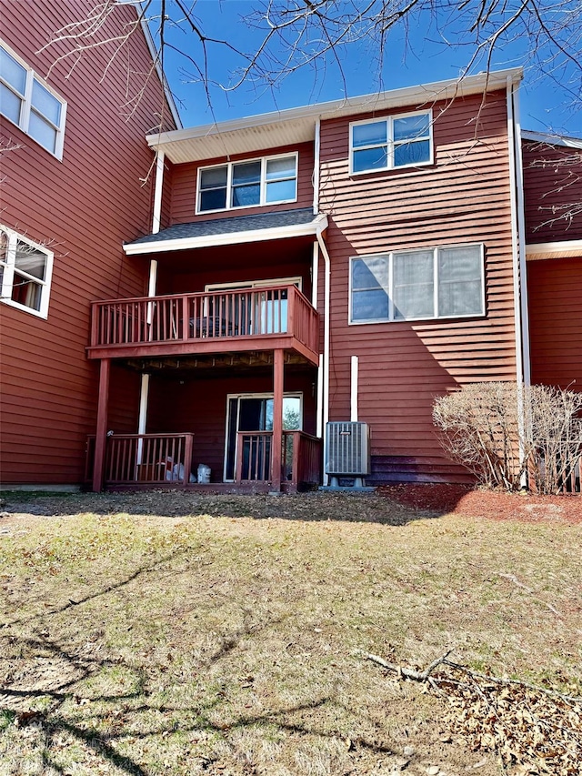 rear view of property featuring a lawn and central AC
