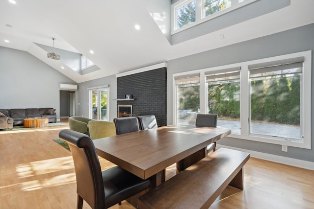 dining space featuring a wall unit AC, light wood-style flooring, and a wealth of natural light