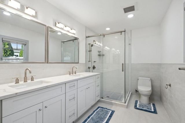 bathroom with a stall shower, visible vents, a sink, and tile walls