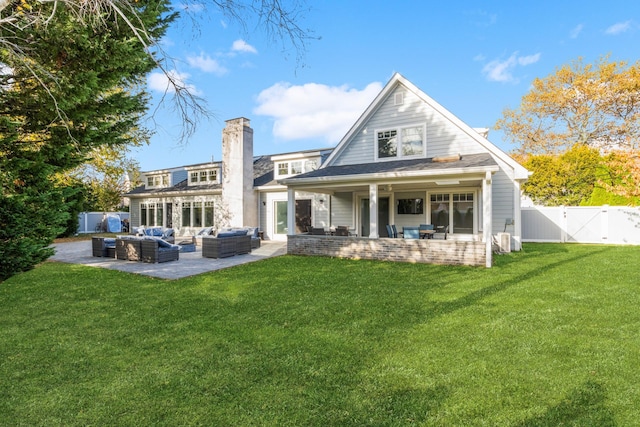 rear view of property featuring a yard, a gate, a patio area, a fenced backyard, and an outdoor living space