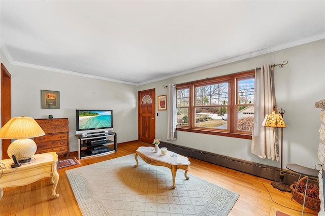 living room with crown molding, baseboards, and wood finished floors