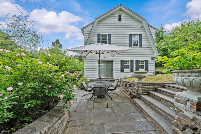 2711 Edgehill Ave, Bronx, NY 10463 - rear view of property with a gambrel roof, a patio, and outdoor dining area