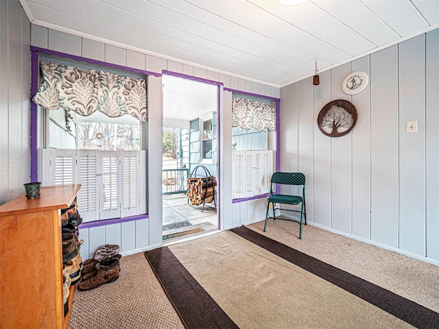 interior space with baseboards, carpet floors, and crown molding