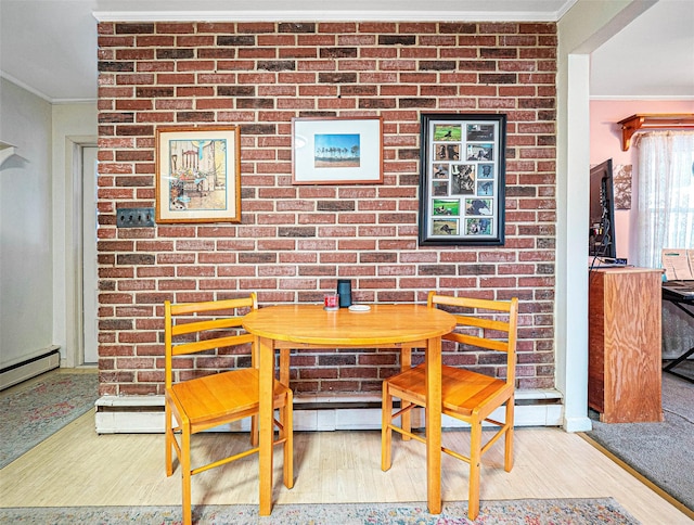 dining room with light wood finished floors, brick wall, ornamental molding, and breakfast area