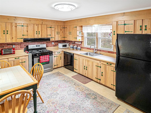 kitchen with a sink, light wood-style floors, ventilation hood, black appliances, and tasteful backsplash