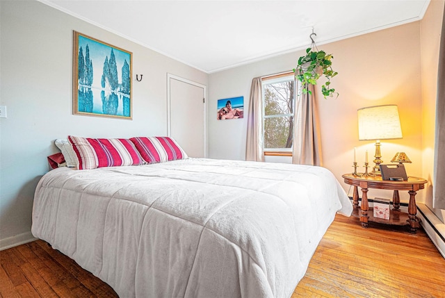 bedroom featuring light wood-style floors, baseboards, and crown molding