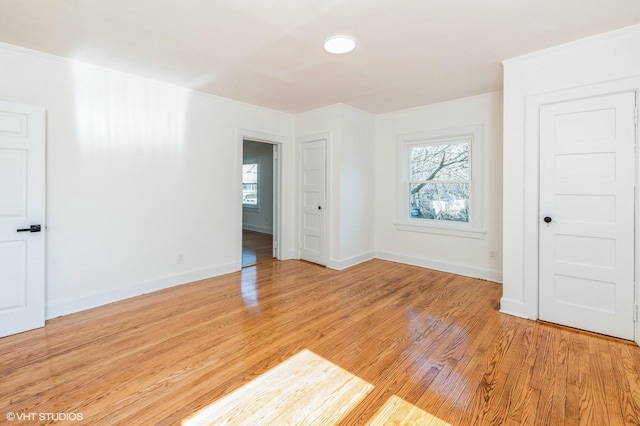 empty room with light wood-type flooring, plenty of natural light, and baseboards