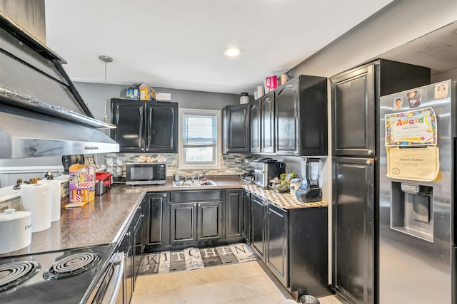 kitchen featuring dark cabinets, a sink, ventilation hood, backsplash, and stainless steel fridge with ice dispenser