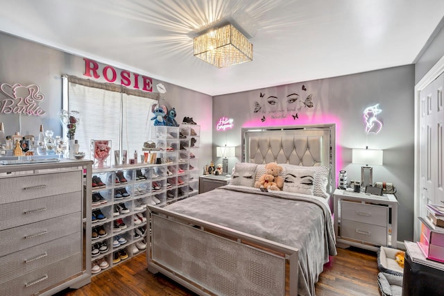 bedroom with a chandelier and wood finished floors