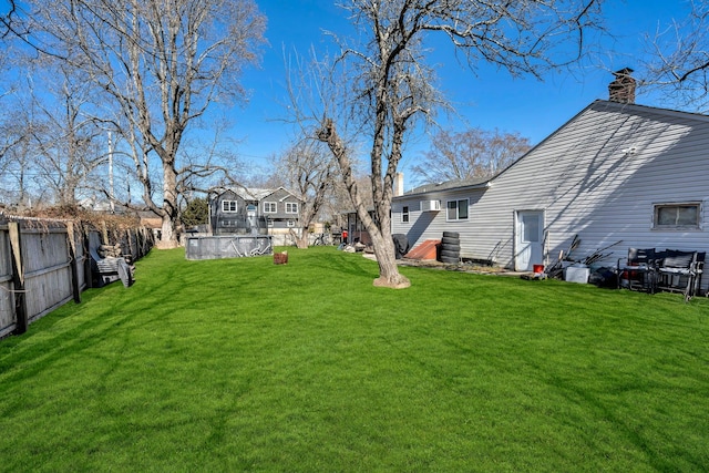 view of yard with fence and a swimming pool