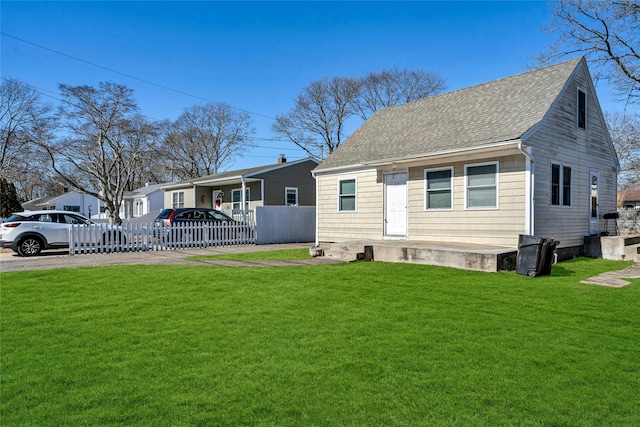 view of front of property featuring a front lawn, roof with shingles, and fence