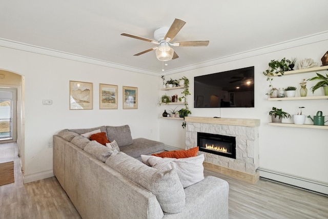 living room featuring ornamental molding, ceiling fan, baseboard heating, and wood finished floors