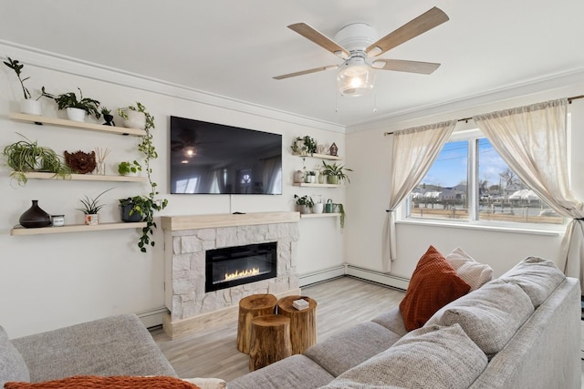 living room with ceiling fan, a fireplace, wood finished floors, and crown molding