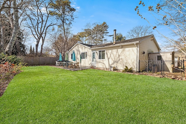 back of property featuring a fenced backyard, a lawn, and a patio