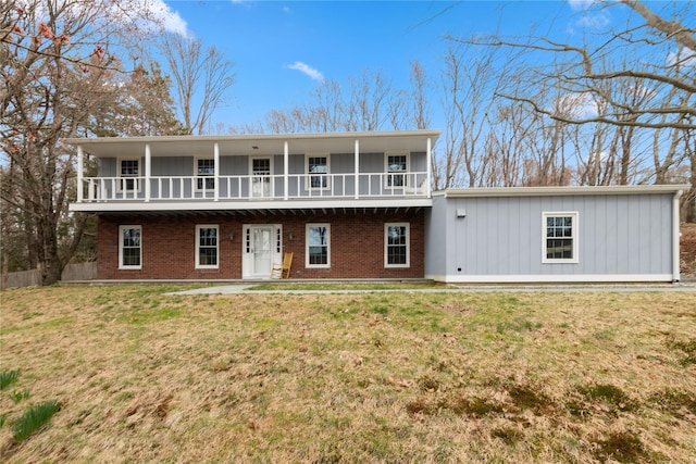 view of front of home featuring brick siding, board and batten siding, and a front yard