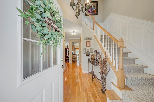 entrance foyer featuring light wood-style flooring, a high ceiling, and stairway