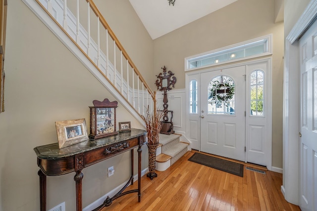 foyer featuring light wood-type flooring, visible vents, and stairway