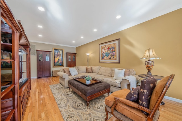 living room featuring light wood-type flooring, baseboards, ornamental molding, and recessed lighting