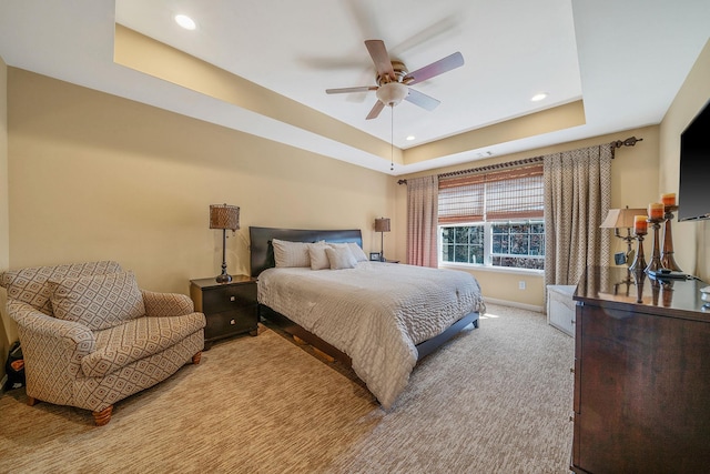 carpeted bedroom featuring ceiling fan, recessed lighting, a raised ceiling, and baseboards