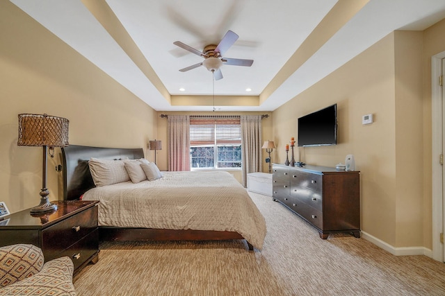 carpeted bedroom featuring ceiling fan, baseboards, a raised ceiling, and recessed lighting