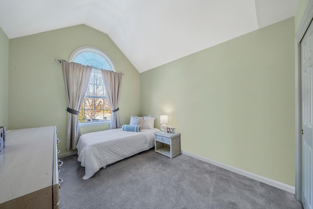 carpeted bedroom featuring lofted ceiling and baseboards