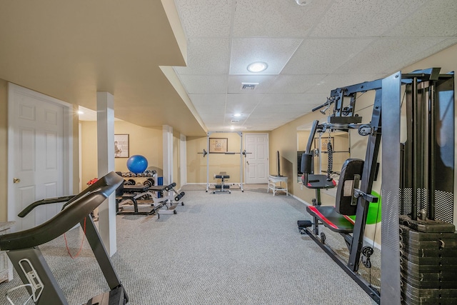 exercise area featuring a paneled ceiling, carpet floors, baseboards, and visible vents