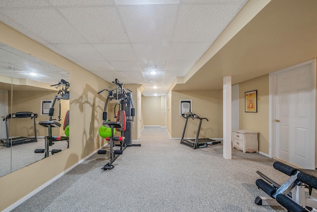 exercise room featuring carpet, a drop ceiling, and baseboards