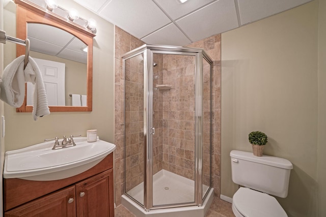 full bath with a stall shower, a drop ceiling, vanity, and toilet