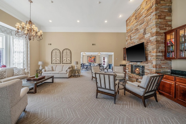 living room featuring a chandelier, a stone fireplace, a high ceiling, carpet flooring, and ornamental molding