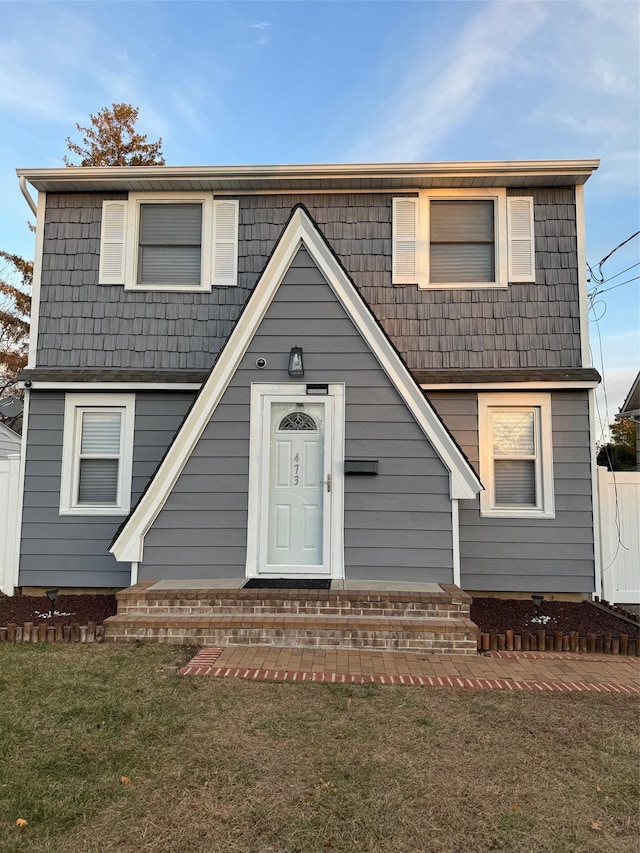 view of front of home with entry steps and a front yard