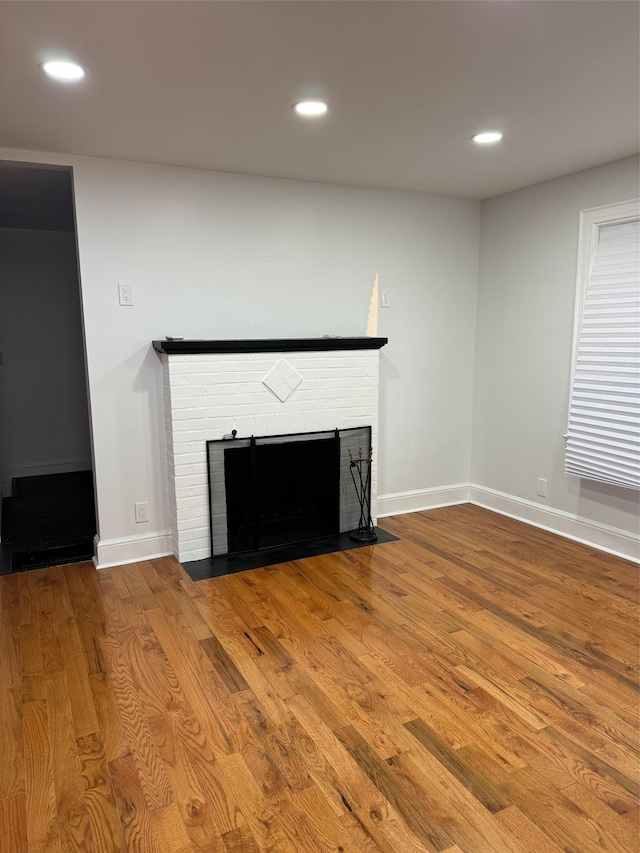 unfurnished living room with a fireplace, wood finished floors, and recessed lighting