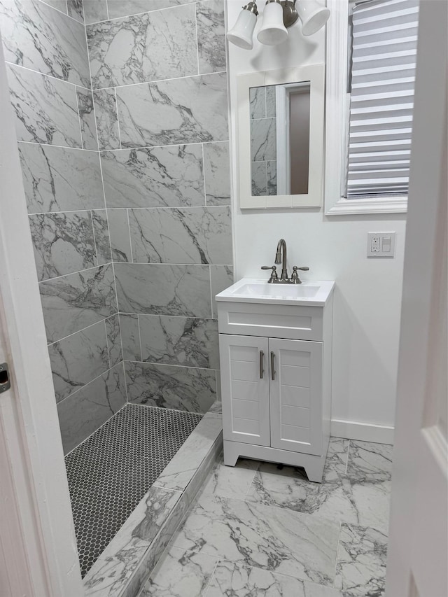 full bathroom featuring marble finish floor, a shower stall, vanity, and baseboards