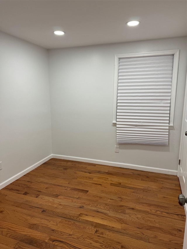 empty room featuring baseboards, wood finished floors, and recessed lighting