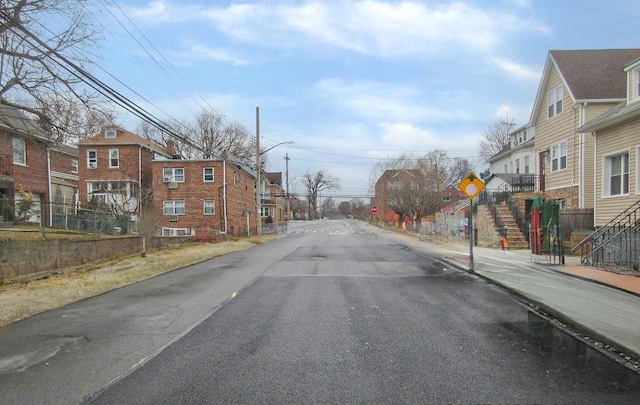 view of road with sidewalks, traffic signs, and a residential view