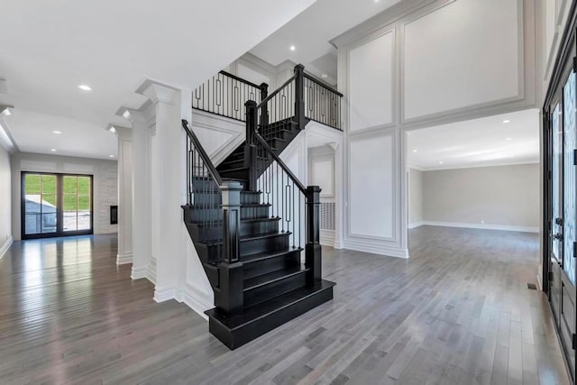 stairway with a fireplace, baseboards, wood finished floors, and recessed lighting