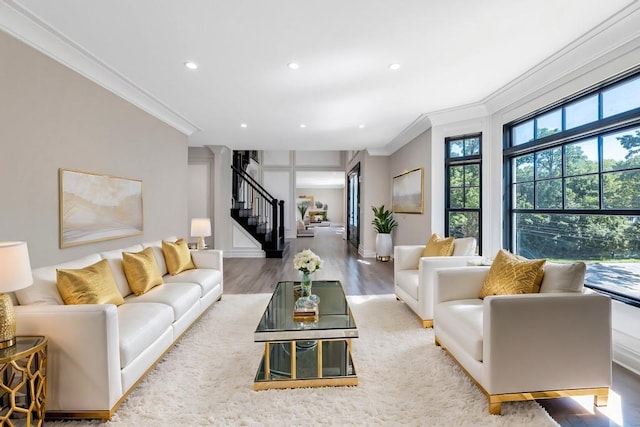 living room with recessed lighting, wood finished floors, baseboards, stairs, and crown molding