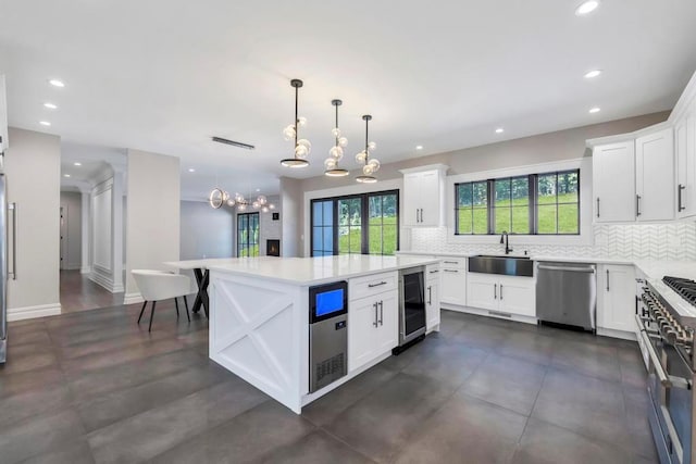 kitchen featuring wine cooler, a sink, light countertops, appliances with stainless steel finishes, and tasteful backsplash