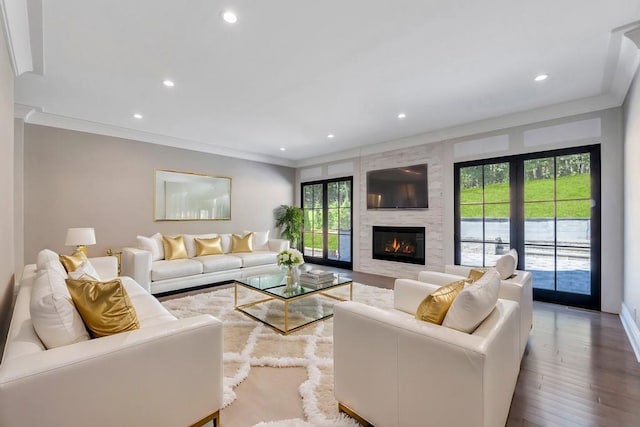 living room featuring a fireplace, recessed lighting, wood finished floors, and crown molding